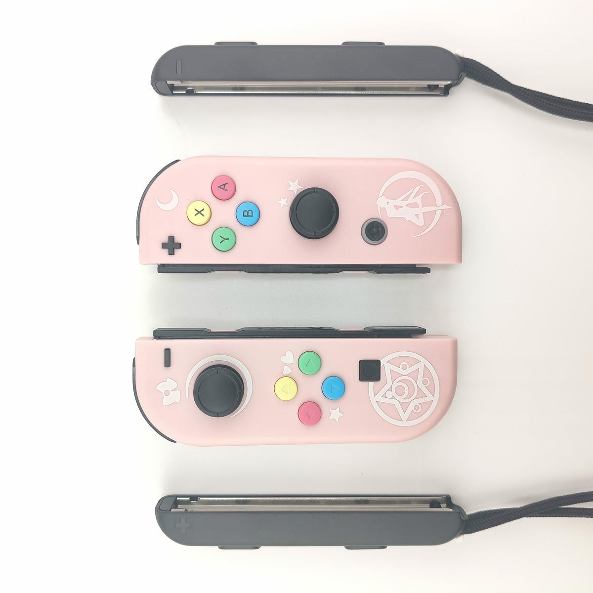 Set controller alternativi per console portatile con grip centrale coordinato, tonalità pastello e design ergonomico ispirato a temi magici.