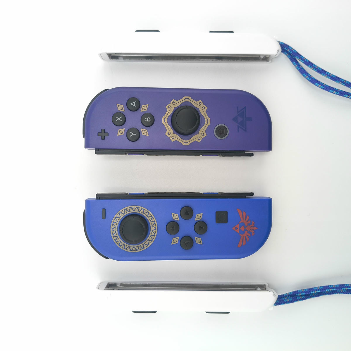 Coppia controller alternativi per console portatile, colorazione blu cobalto e viola scuro, inclusi laccetti di sicurezza bianchi.