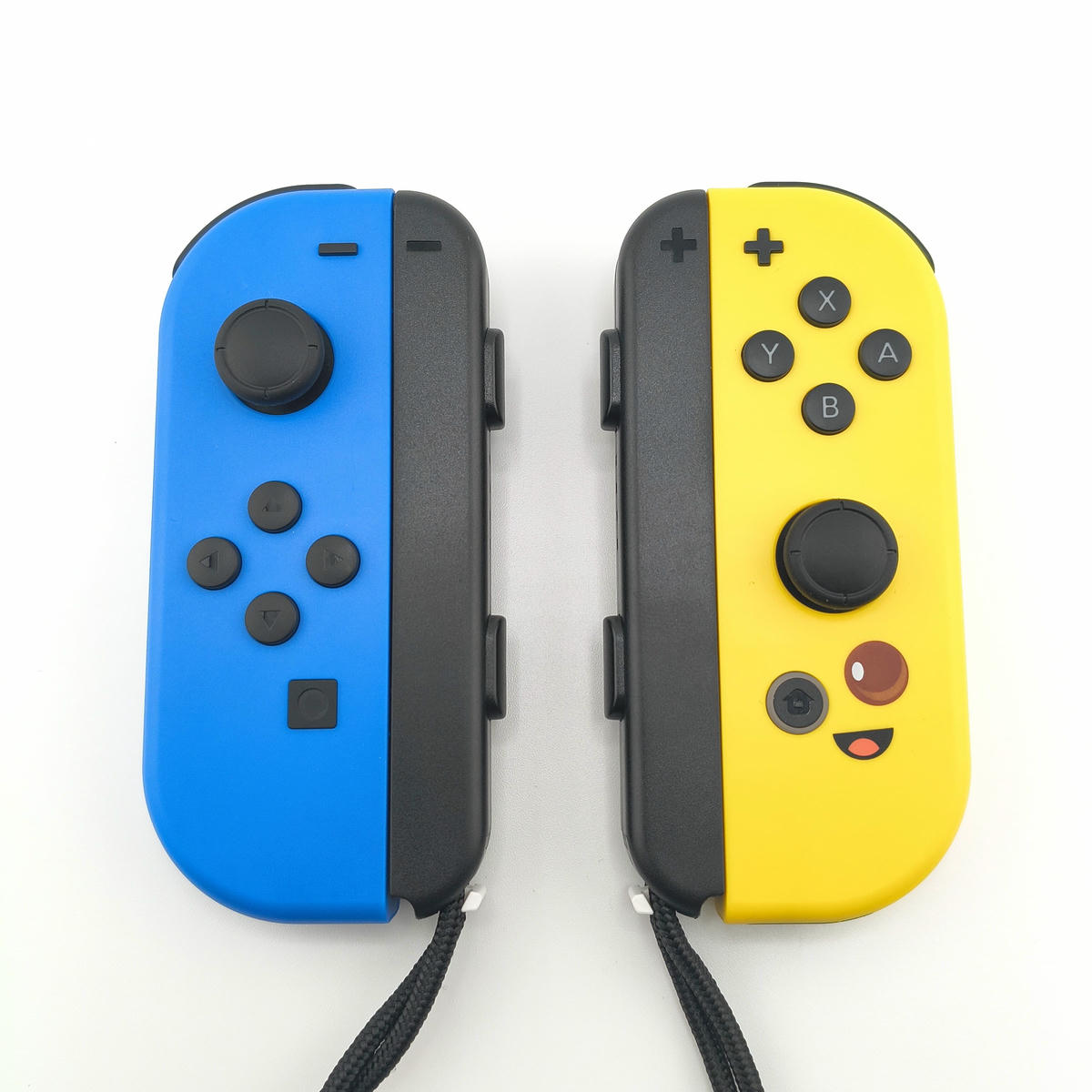 Coppia di controller wireless Soamide edizione Bananita giallo e blu per console portatile, design ergonomico con icone grafiche e vibrazione integrata.