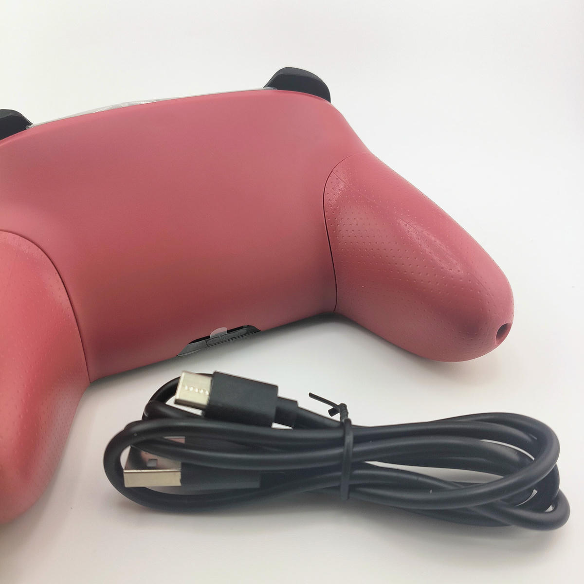 Vista posteriore del controller ro Soamide con cavo di ricarica USB incluso, design ergonomico della scocca studiato per il massimo comfort durante le lunghe sessioni.