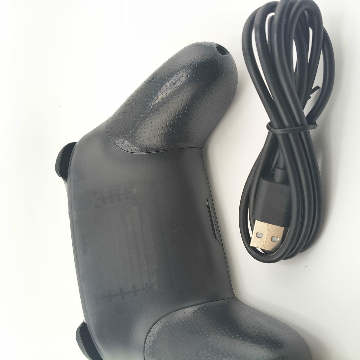 Vista posteriore del controller Pro Soamide con cavo di ricarica USB incluso, design ergonomico studiato per il massimo comfort  stabilità dell'impugnatura.