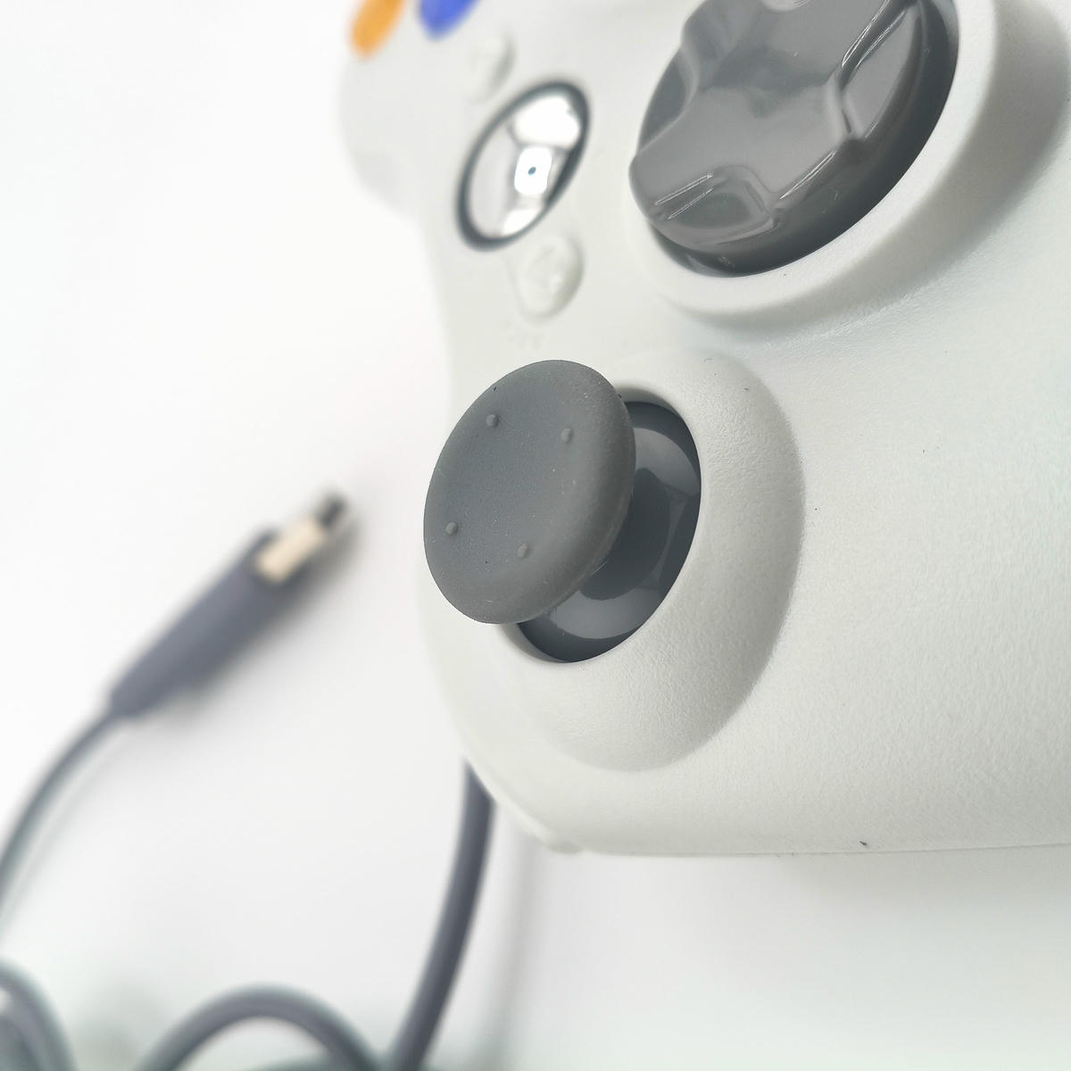 Dettaglio macro della levetta analogica antiscivolo e tasti funzione del controller Soamide bianco, texture ad alto grip per massima precisione di movimento nel gaming.